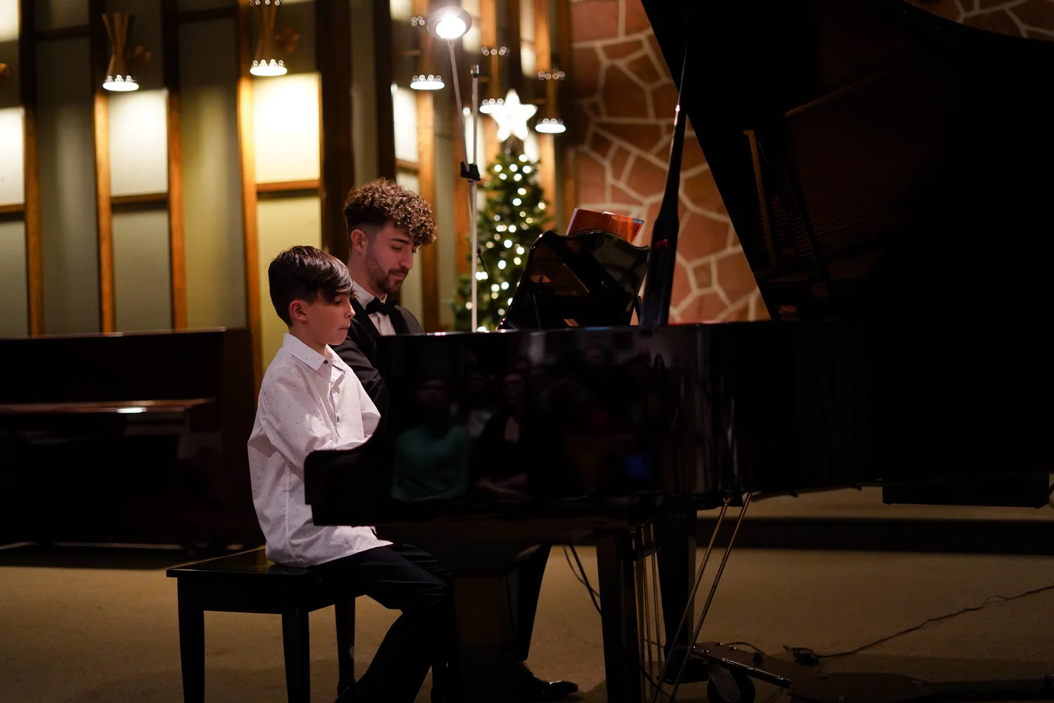 Jean-Baptiste accompagne un élève lors d’un concert PianoPiano!